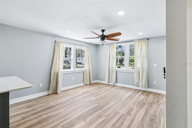 5632 Indiana Ave, New Port Richey, FL 34652 - empty room with light wood finished floors, a ceiling fan, recessed lighting, a textured ceiling, and baseboards