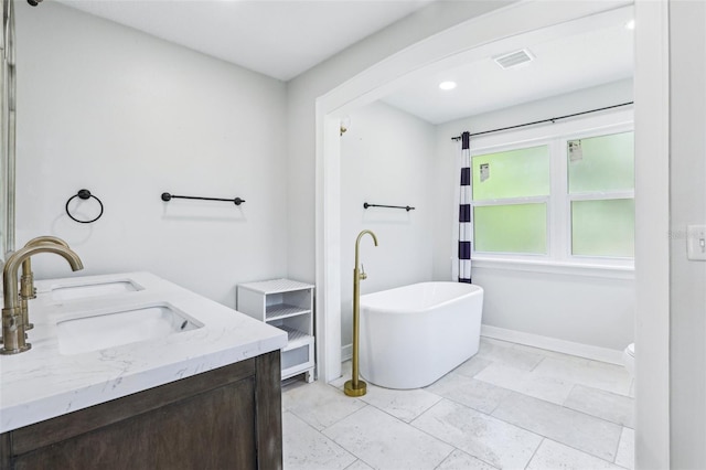 5632 Indiana Ave, New Port Richey, FL 34652 - bathroom featuring a freestanding bath, baseboards, recessed lighting, and double vanity
