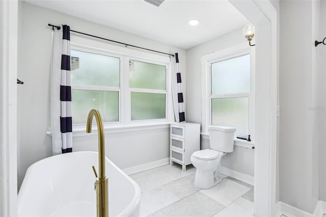 5632 Indiana Ave, New Port Richey, FL 34652 - bathroom featuring a freestanding tub, healthy amount of natural light, baseboards, toilet, and recessed lighting