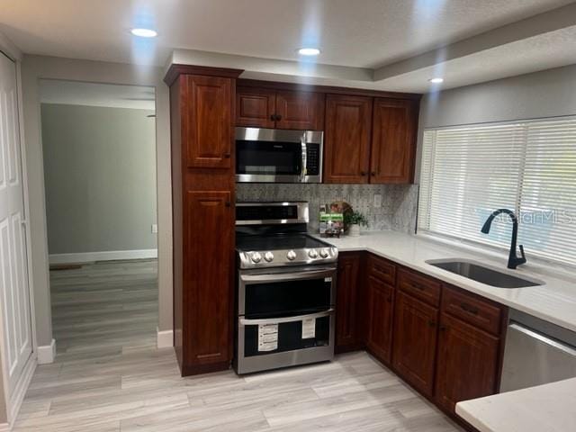 12415 Stagecoach Ln, Hudson, FL 34667 - kitchen with stainless steel appliances, a sink, tasteful backsplash, light countertops, and baseboards