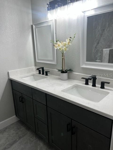 12415 Stagecoach Ln, Hudson, FL 34667 - full bathroom featuring double vanity, baseboards, and a textured wall
