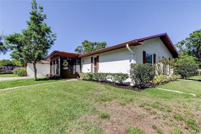2380 Shelly Dr Unit B, Palm Harbor, FL 34684 - view of front of home with stucco siding, a front yard, and an attached garage