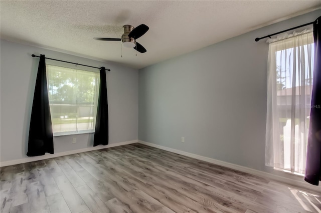 2380 Shelly Dr Unit B, Palm Harbor, FL 34684 - empty room with healthy amount of natural light, ceiling fan, wood finished floors, and a textured ceiling