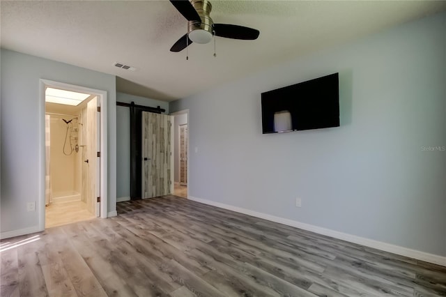2380 Shelly Dr Unit B, Palm Harbor, FL 34684 - unfurnished bedroom featuring wood finished floors, baseboards, ensuite bathroom, and a ceiling fan