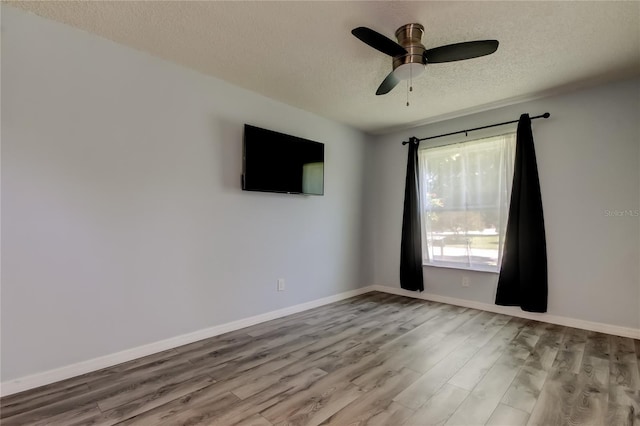 2380 Shelly Dr Unit B, Palm Harbor, FL 34684 - empty room with a textured ceiling, wood finished floors, ceiling fan, and baseboards