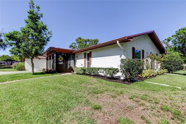 2380 Shelly Dr Unit B, Palm Harbor, FL 34684 - view of front of home with stucco siding, a front yard, and an attached garage