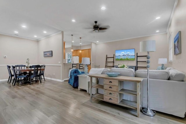 living room featuring ceiling fan, ornamental molding, light wood-style flooring, recessed lighting, and baseboards