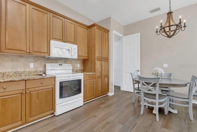 kitchen featuring white appliances, a chandelier, light wood-type flooring, backsplash, and light stone counters
