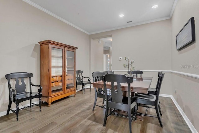 dining space with light wood-type flooring, baseboards, ornamental molding, and recessed lighting