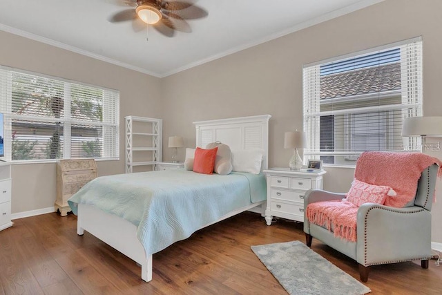 bedroom with crown molding, wood finished floors, baseboards, and a ceiling fan