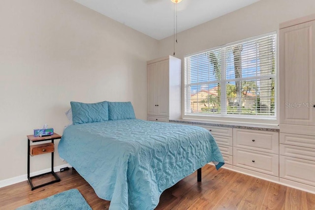 bedroom featuring wood finished floors and baseboards