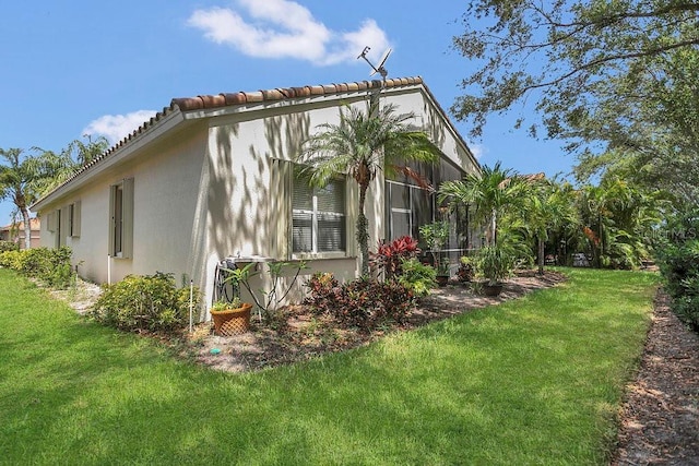 view of side of home featuring stucco siding and a lawn