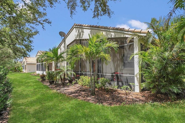 rear view of house with a yard and a sunroom