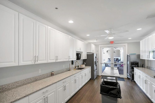 kitchen with stainless steel appliances, a sink, white cabinetry, dark wood-style floors, and a ceiling fan