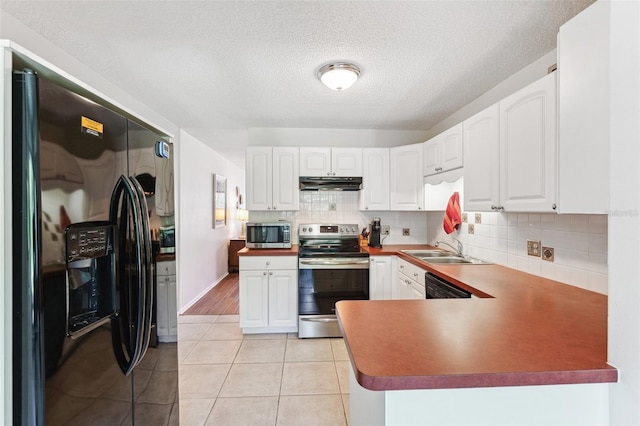 kitchen with black appliances, under cabinet range hood, a sink, tasteful backsplash, and white cabinets