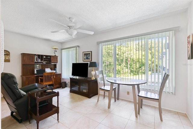 living room featuring ceiling fan, a textured ceiling, and light tile patterned floors