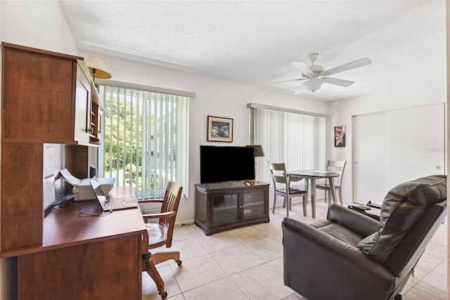 living area featuring a textured ceiling, ceiling fan, light tile patterned flooring, and a desk