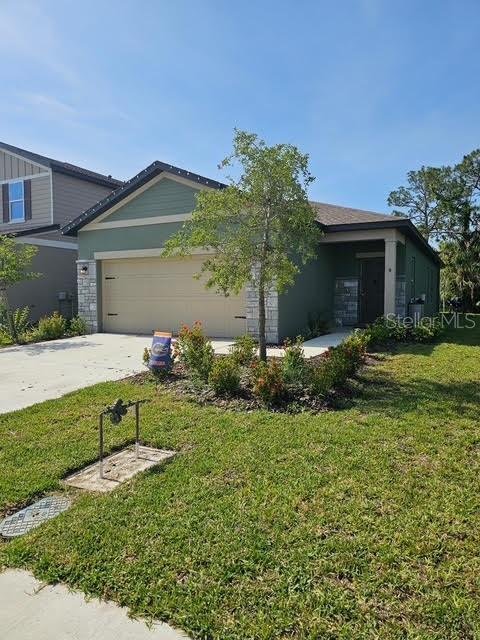 10607 Ladybug Cv, Parrish, FL 34219 - view of front facade featuring an attached garage, a front lawn, and driveway