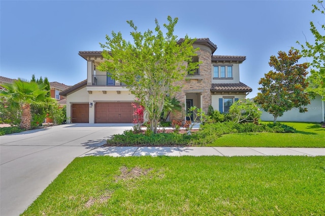 mediterranean / spanish-style home featuring a garage, concrete driveway, a tiled roof, stucco siding, and a front yard