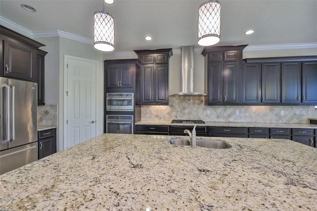 kitchen with wall chimney exhaust hood, stainless steel appliances, a sink, light stone countertops, and decorative backsplash