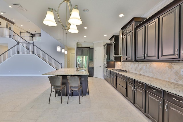 kitchen with stainless steel appliances, light stone counters, a kitchen breakfast bar, pendant lighting, and crown molding