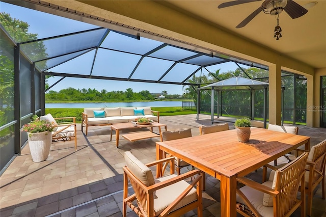 view of patio featuring a water view, an outdoor hangout area, a lanai, and ceiling fan