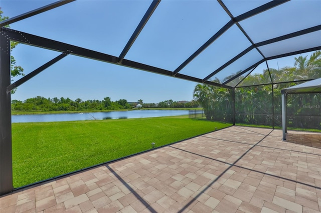 view of patio featuring a water view and glass enclosure