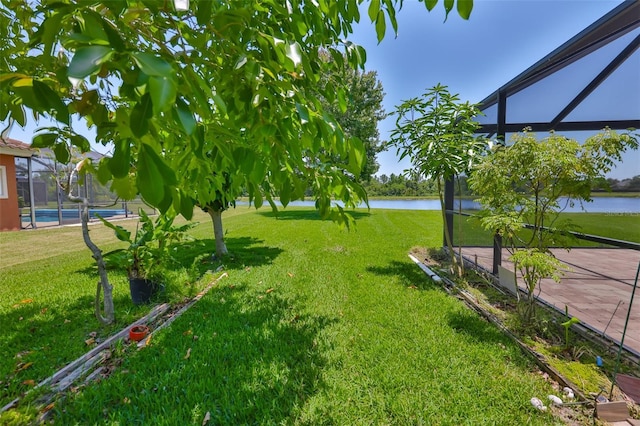 view of grassy yard featuring a water view and an outdoor pool
