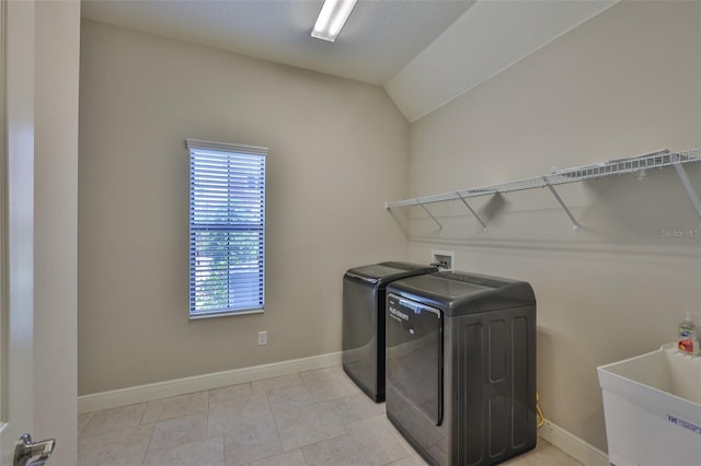 washroom with washer and clothes dryer and baseboards
