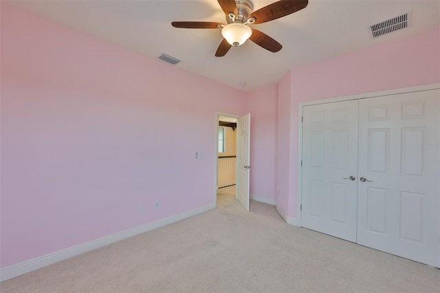 unfurnished bedroom featuring light carpet, baseboards, a closet, and ceiling fan