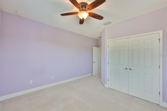 unfurnished bedroom with light colored carpet, baseboards, a closet, and ceiling fan