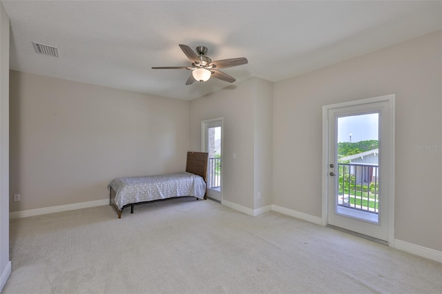 bedroom with access to outside, light carpet, and baseboards