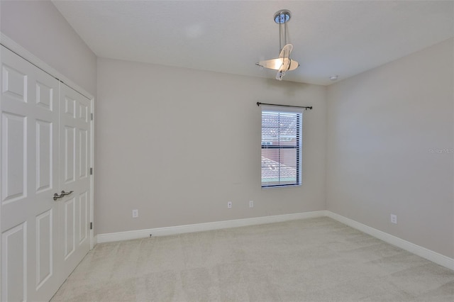 unfurnished bedroom featuring light colored carpet and baseboards