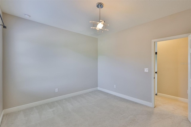 unfurnished room featuring light carpet and baseboards