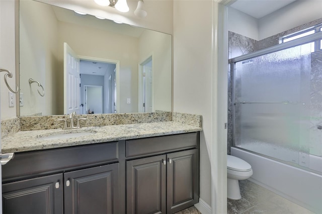 full bathroom with vanity, bath / shower combo with glass door, and toilet