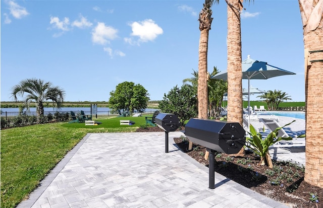 1075 Silverlake Blvd, Lake Alfred, FL 33850 - view of patio / terrace with a swimming pool, a water view, and a grill