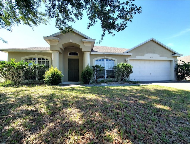 451 Peace Ct, Kissimmee, FL 34759 - view of front facade with an attached garage, stucco siding, driveway, and a front yard