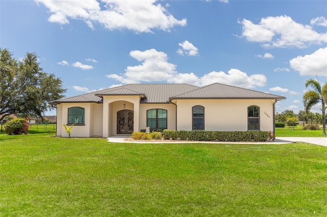 2484 SW 33rd Cir, Okeechobee, FL 34974 - mediterranean / spanish-style home with stucco siding, a front yard, a standing seam roof, and a metal roof