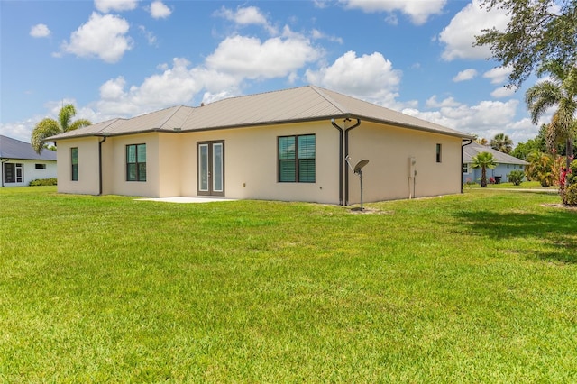 2484 SW 33rd Cir, Okeechobee, FL 34974 - back of house with stucco siding, french doors, a lawn, and a metal roof