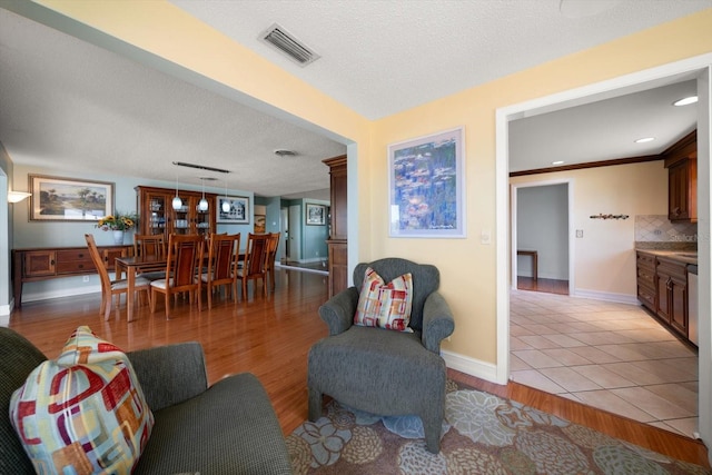1963 Edgewater Dr, Clearwater, FL 33755 - living area featuring baseboards, light wood-style floors, and a textured ceiling