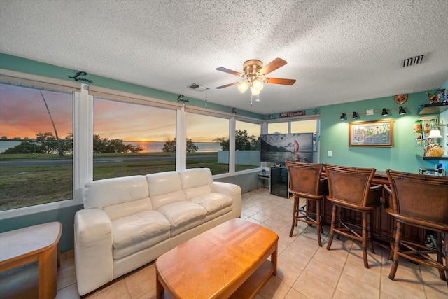 1963 Edgewater Dr, Clearwater, FL 33755 - tiled living area with a ceiling fan, a bar, and a textured ceiling