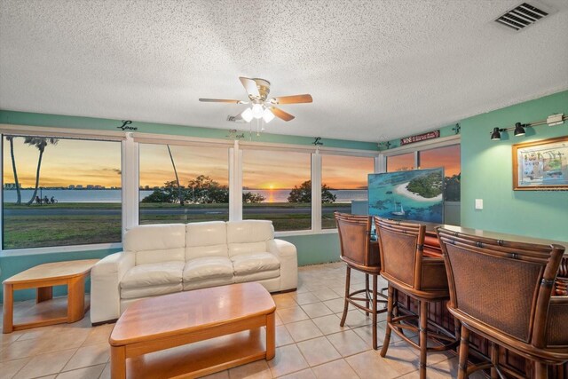 1963 Edgewater Dr, Clearwater, FL 33755 - living room with a ceiling fan, light tile patterned flooring, a textured ceiling, and a dry bar