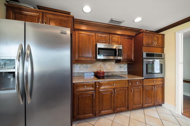1963 Edgewater Dr, Clearwater, FL 33755 - kitchen featuring appliances with stainless steel finishes, decorative backsplash, light tile patterned floors, light stone countertops, and baseboards
