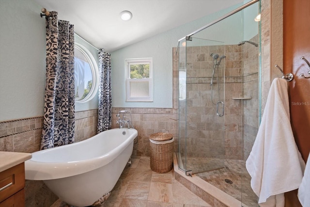 1963 Edgewater Dr, Clearwater, FL 33755 - bathroom with tile walls, a shower stall, a freestanding bath, lofted ceiling, and vanity