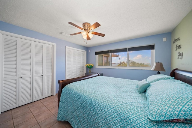 1963 Edgewater Dr, Clearwater, FL 33755 - bedroom with two closets, tile patterned flooring, a textured ceiling, and a ceiling fan