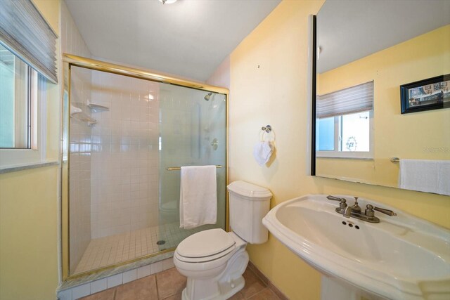 1963 Edgewater Dr, Clearwater, FL 33755 - bathroom with a stall shower, a sink, toilet, and tile patterned flooring