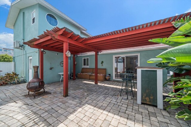 1963 Edgewater Dr, Clearwater, FL 33755 - view of patio with a pergola, an outdoor fire pit, a hot tub, and fence
