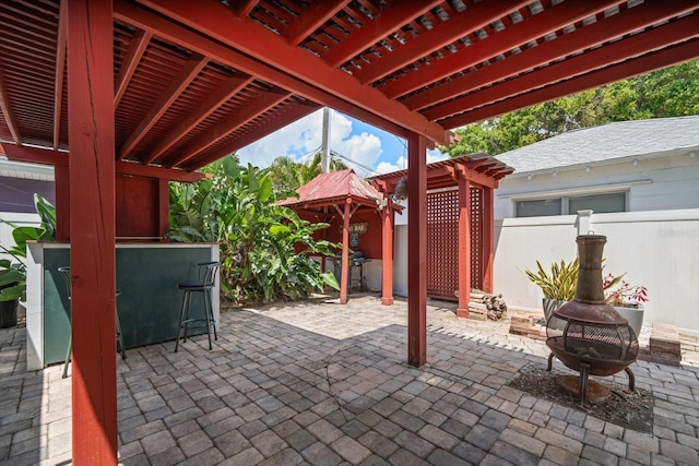 1963 Edgewater Dr, Clearwater, FL 33755 - view of patio with a pergola, fence, and an outdoor fire pit