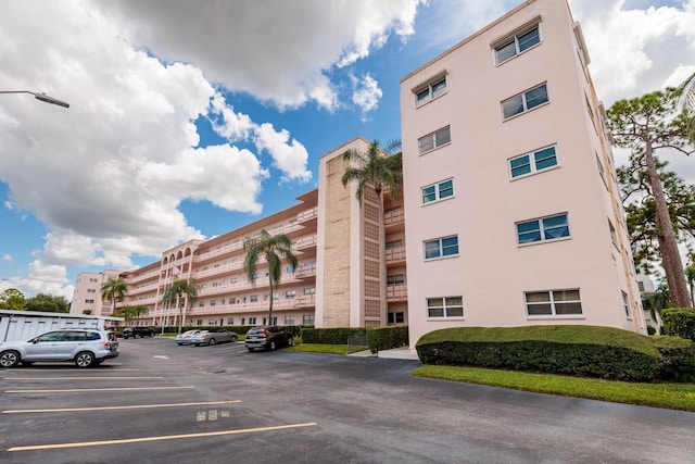 view of apartment building / complex featuring uncovered parking
