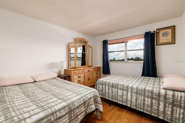 bedroom with wood finished floors and a textured ceiling